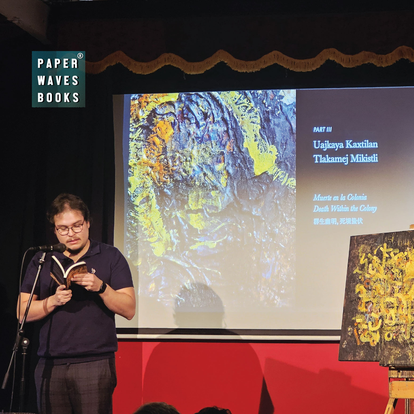 A reading from Obsidian Sun with multilingual poetry projected beside the cover artwork
